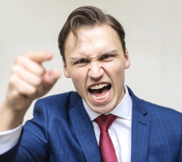 Young businessman screaming against someone